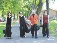 Photo of quartet walking towards the camera, instruments in hand