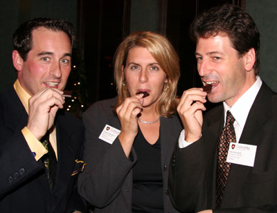 Jordan LeBel (above, left) tries a piece of African chocolate with Laura Stanbra, director of alumni relations and development, and Sean Sprackett, new president of the Concordia alumni association.